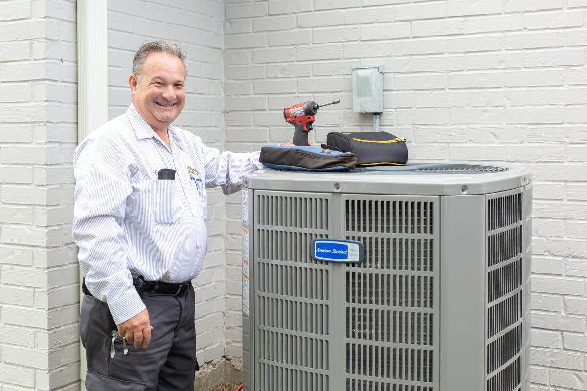 HVAC technician working on an outdoor AC unit
