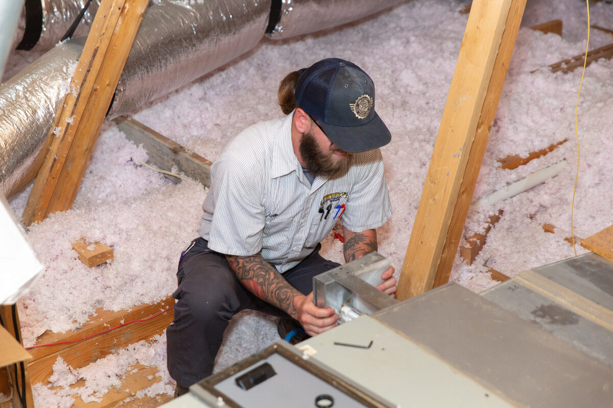 HVAC technician repairing equipment with tools